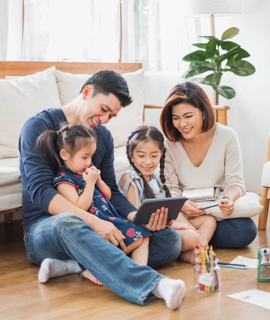 Family sitting on floor in living room – Protect your home with termite & pest control service Family sitting on floor in living room - Protect your home with termite & pest control service